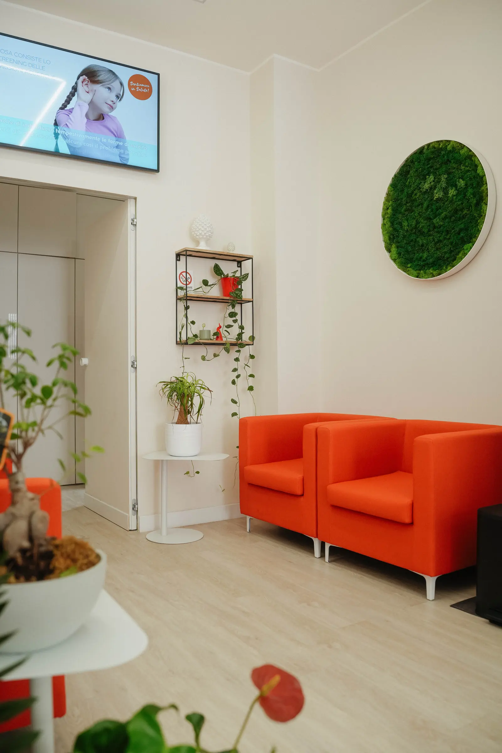 Sala d'attesa del centro Otosense, con le poltrone arancioni.
